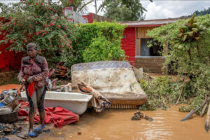 A resident salvages her household items washed away in the Rubavu district in Rwanda.(Reuters: Jean Bizimana)